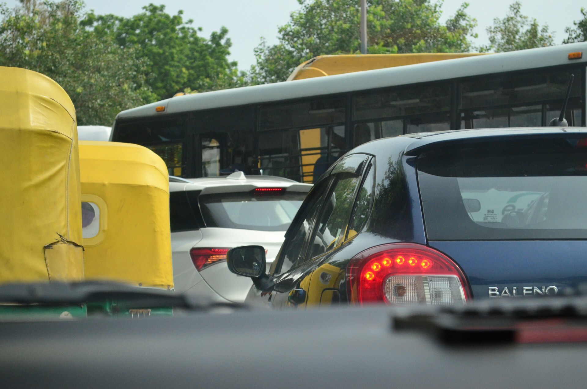 Auto, buses, and cars stuck in heavy traffic on a busy street, showcasing traffic jams during festivities in India.